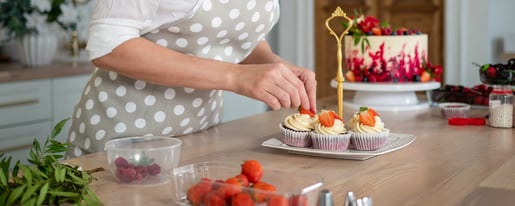 Woman decorating cupcakes strawberries